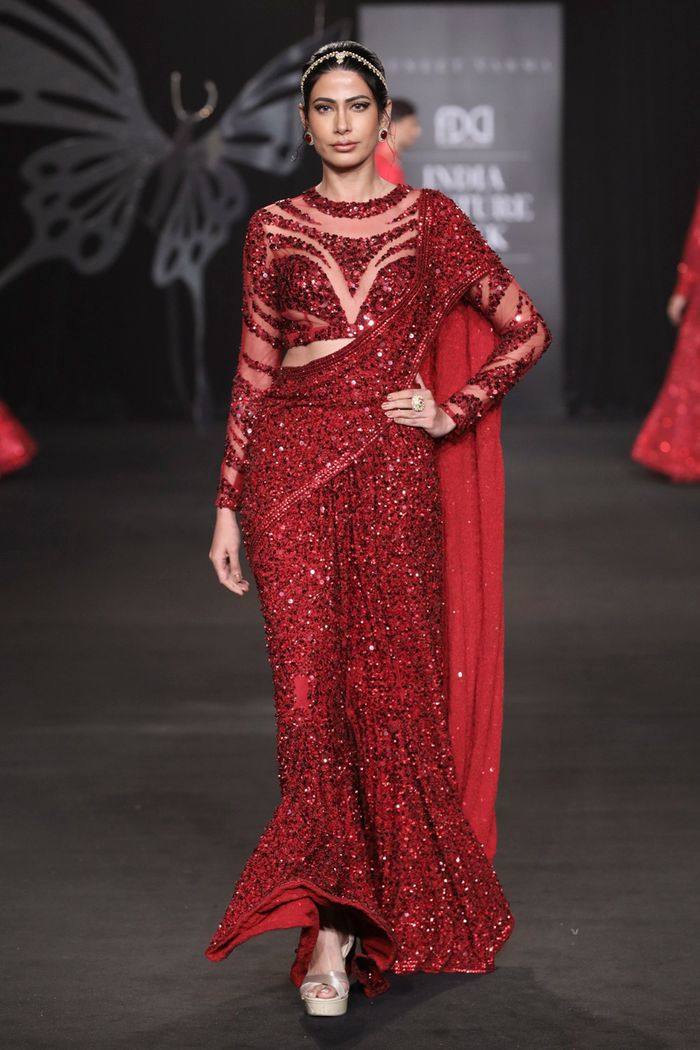 Stunning model in a glittering red dress at a fashion show in New Delhi, India.